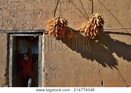 ANHUI PROVINCE, CHINA - CIRCA OCTOBER 2017: An old women in front of her house in the Yangchan tulou, the chinese rural earthen dwelling in Anhui province in China.