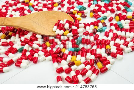 Colorful of antibiotic capsules pills and wood spoon on white background. Drug resistance concept. Antibiotics drug use with reasonable and global healthcare concept.