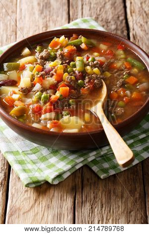 American Hamburger Soup With Ground Beef And Mix Of Vegetables Close-up On The Table. Vertical
