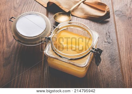 Desi Ghee or clarified butter in glass or Copper container or ceramic jar with spoon, selective focus