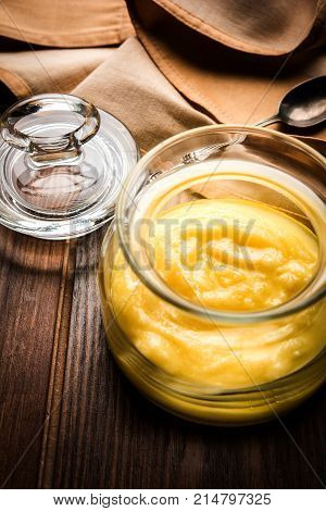 Desi Ghee or clarified butter in glass or Copper container or ceramic jar with spoon, selective focus