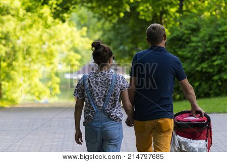 Young couple walking with child in the Park. Summer.