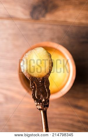 Desi Ghee or clarified butter in glass or Copper container or ceramic jar with spoon, selective focus