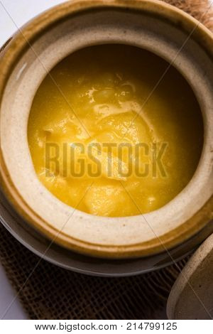 Desi Ghee or clarified butter in glass or Copper container or ceramic jar with spoon, selective focus