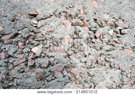Red stones immured in gray berot. The background. Texture.