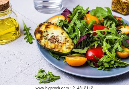 Raw arugula with vegetables and citrus. Selective focus.