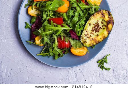 Raw arugula with vegetables and citrus. Selective focus.
