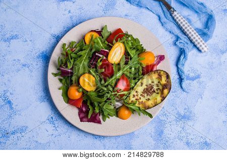 Raw arugula with vegetables and citrus. Selective focus.