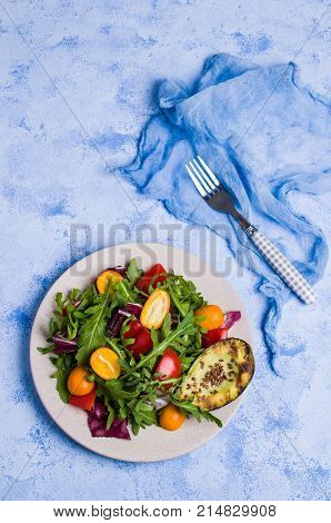 Raw arugula with vegetables and citrus. Selective focus.