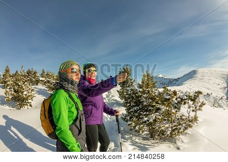 Pair Of Tourist Girls Watching The Trail In The Winter Mountains