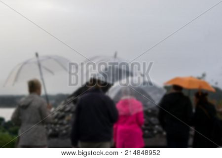 Blur shot of Tourists are watching Fuji simulator in front of Kawaguchiko lank and mount Fuji with rainy day in Japan