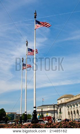 Tre amerikanske flag vajende stolt på høje Flagstænger