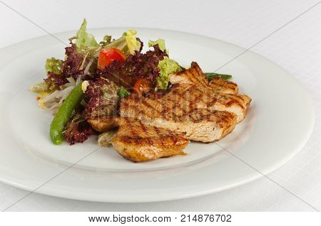 Vegetable salad with grilled turkey on white background