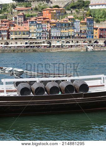 Traditional Rabelo Boat on the Bank of the River Douro and Colorful Facades of Typical Houses- Porto Portugal.