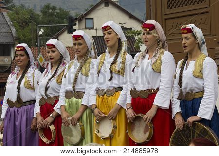 SARAJEVO, BOSNIA AND HERZEGOVINA - AUGUST 20 2017: Group of traditional dressed bosnian girls in front of Sebilj fountain holding tambourines