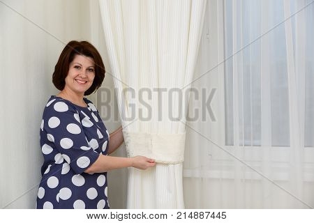 Woman puts a clamps on the curtains