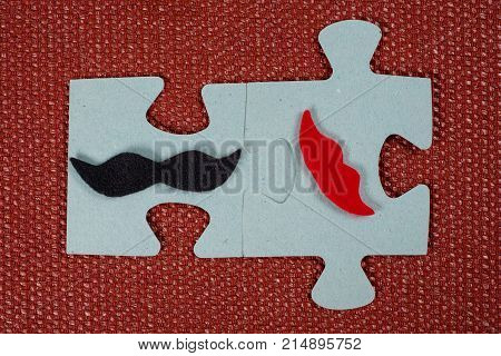Close-up Of 2 Pieces Of A Puzzle. A Symbolic Man With A Mustache And A Woman With Lips. The Concept