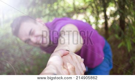 The young man pulls the girl's hand. Forest. Summer.