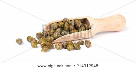 Capers in wooden spoon isolated on white background. Canned capers
