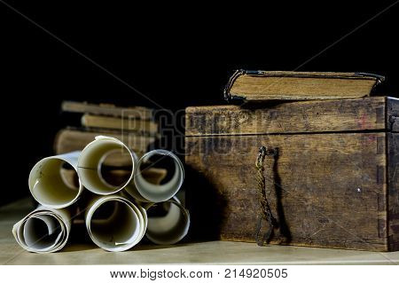 Old Rolls And Plans In Folded Paper Rolls. Old Book And Case. Documents On An Old Wooden Table.