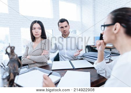 The couple went to a lawyer to conclude an agreement on the divorce. They quarrel and argue with each other. Lawyer prepares documents.