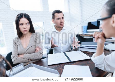 The couple went to a lawyer to conclude an agreement on the divorce. They quarrel and argue with each other. Lawyer prepares documents.