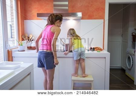 Little Child Cooking With Mother Supervising