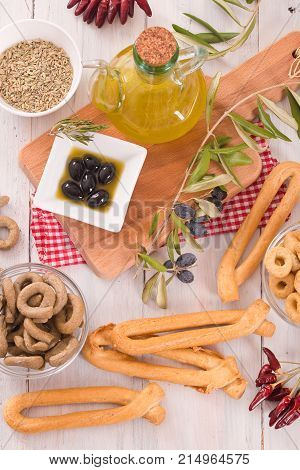 Italian taralli with olives and spices on wooden table.