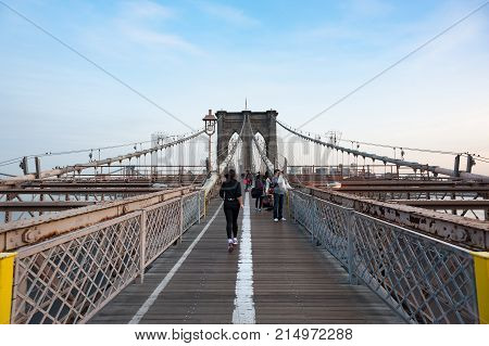 New york City, USA - Nov 14, 2011: Woman running on the Brooklyn bridge with tourists in the background.