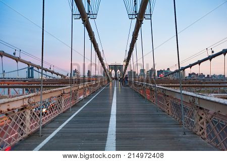 New york City, USA - Nov 14, 2011: Tourists on the Brooklyn bridge at dusk.