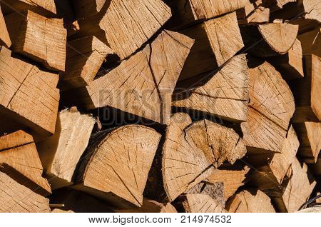 A pile of stacked firewood, prepared for heating the house. Firewood harvested for heating in winter. Chopped firewood on a stack. Firewood stacked and prepared for winter Pile of wood logs. High-quality wood, cut and stacked.