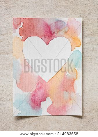 painting, drawing, pattern concept. on the wooden desk there is greeting card that id made by artist with watercolores and consrtuction paper that has rough surface
