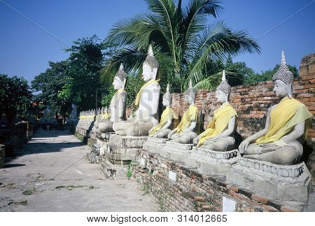 Images Of The Meditating Buddha Sits Serenely In A Row In Front Of The Ruins Of A Chedi At Wat Yai C