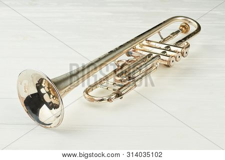 Rusty Trumpet On Light Background. Old Musical Instrument On White Wooden Background. Classical Jazz