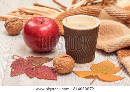 Cup Of Coffee, Walnut, Apple And Dry Leaves In An Autumn Still Llife.