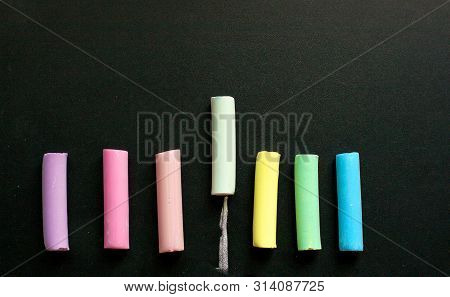 Crayons Of Different Colors Lie On The Slate Ieave A Trace