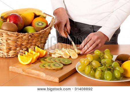 Attractive Young Woman Cuting Fruits And Preparing Fruit Salad