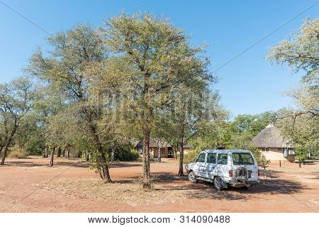 Kruger National Park, South Africa - May 6, 2019: Camping At Satara Rest Camp. A Vehicle And Chalets