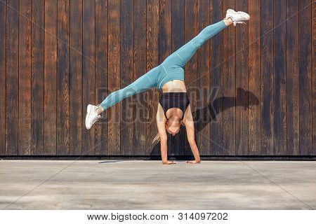 Beautiful Athletic Young Girl Gymnast In Sportswear, Working Out, Element Of Gymnastics, Doing The S