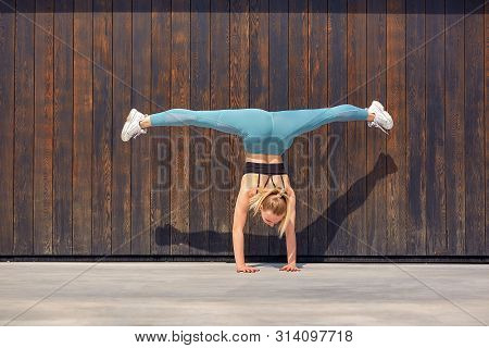 Beautiful Athletic Young Girl Gymnast In Sportswear, Working Out, Element Of Gymnastics, Doing The S