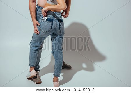 Cropped View Of Young Couple Hugging While Girl Putting Condom From Pack