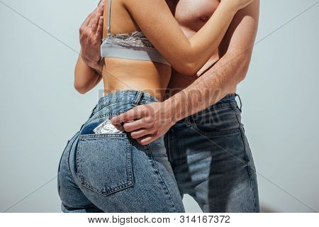 Cropped View Of Naked Man Putting Off Condom From Jeans Of Girl While Hugging