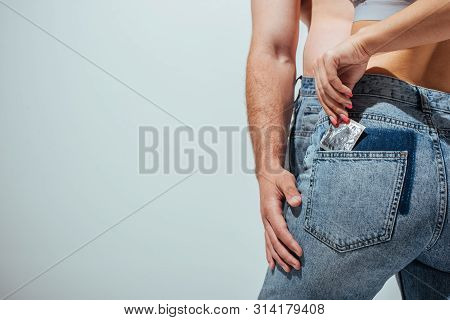 Cropped View Of Girl Putting Off Condom From Jeans While Muscular Man Touching Girlfriend