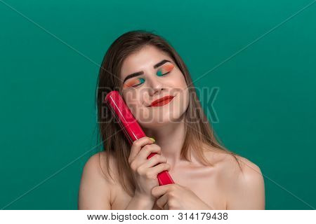 Portrait Of Beautiful Young Woman With Bright Color Make-up Doing Hair Style Herself With A Purple S