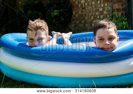 Preteen Boys Laying In A Paddling Pool