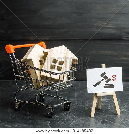 Wooden Houses In A Supermarket Cart. Uction For The Purchase Of Housing And Buildings. The Growth Of