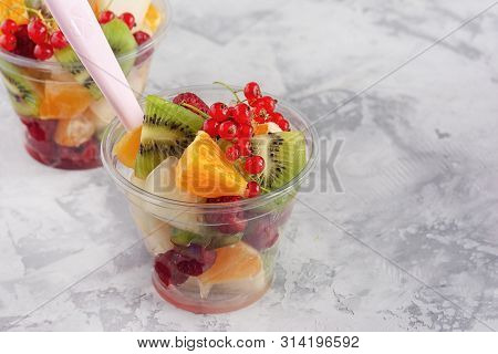 Fresh Ingredient For Fruit Berry Salad Plastic Cup. Low Calorie Vegetarian Snack To Go On Concrete T