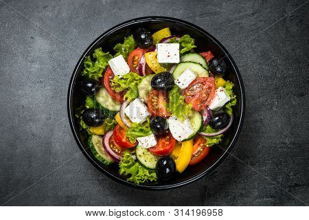 Greek Salad. Vegetable Salad From Tomato, Cucumber, Feta Cheese And Olive Oil On Black Stone Table. 