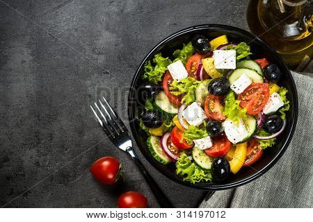 Greek Salad. Vegetable Salad From Tomato, Cucumber, Feta Cheese And Olive Oil On Black Stone Table. 