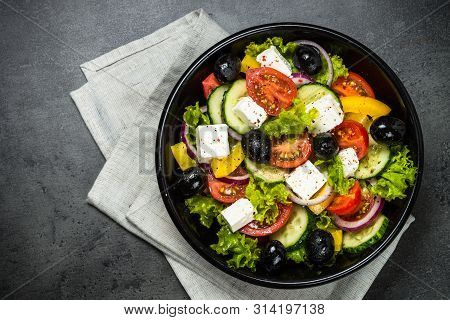 Greek Salad. Vegetable Salad From Tomato, Cucumber, Feta Cheese And Olive Oil On Black Stone Table. 